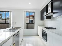 Experience modern living in this thoughtfully designed space, featuring crisp Vivid White ceilings and Vivid White walls that create a fresh, light-filled interior. The kitchen showcases sleek white gloss bottom cupboards paired with Shannon Oak matt top cupboards, perfectly complemented by a 20mm Luna White Caesarstone benchtop for a refined, contemporary finish. Soft white kitchen tiles enhance the clean aesthetic, while the white gloss subway splashback tiles add a touch of timeless style. With cloud vertical blinds and Woodland Grey window frames, every detail has been carefully selected to deliver a modern, elegant, and welcoming home.